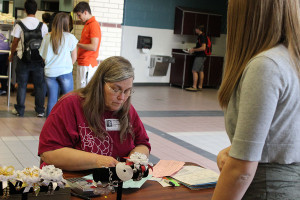 Priscilla Webking, head coordinator for the mum committee, is filling out an order from for a mum order during C lunch on Sept. 23. Photo by Kathryn Skinner.