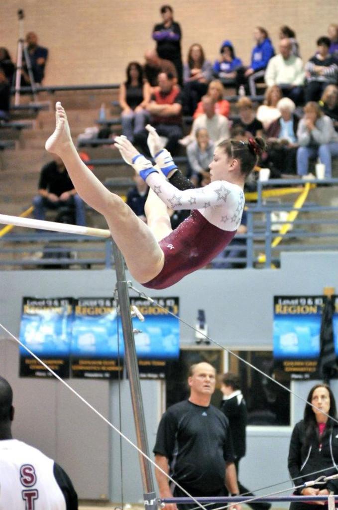Maegan Higdon, who practices 25-30 hours a week, competes in a gymnastics competition on bars. Photo submitted by Maegan Higdon.