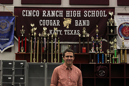 William Schieffer, former member of the Cougar Band, poses in the Band Hall he practiced in as a student. Having been a Cinco student and being a Cinco teacher now, I just feel like I can relate more with what they’re going through, Schieffer said. 