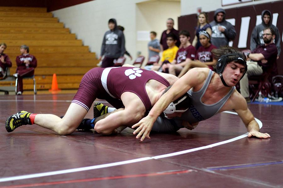 Junior Blake Williams tries to maneuver to expose his opponents back to the mat to gain points. 