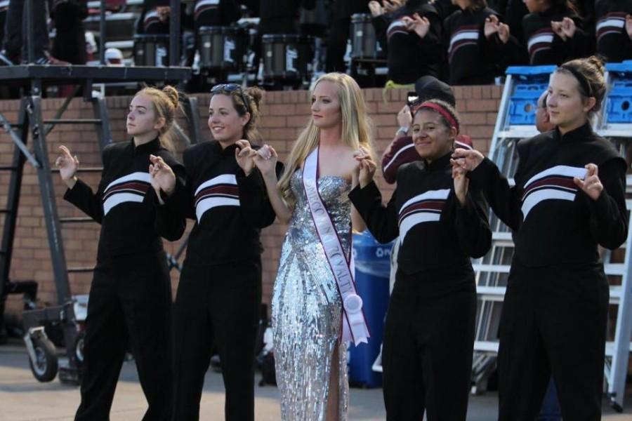 From left to right: Julia Culp, Daniela Ichter, Abby Draut, Susanna Simmonds, and Kyran Hogan all link pinkies and cross their fingers as the band plays the alma mater. 