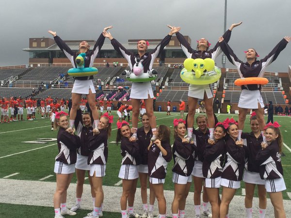 Varsity Cheerleaders encourage the fans on a soggy day Saturday at Rhodes Stadium. The "white out" theme became "flood out" the Spartans as the varsity downed Seven Lakes 24-12.