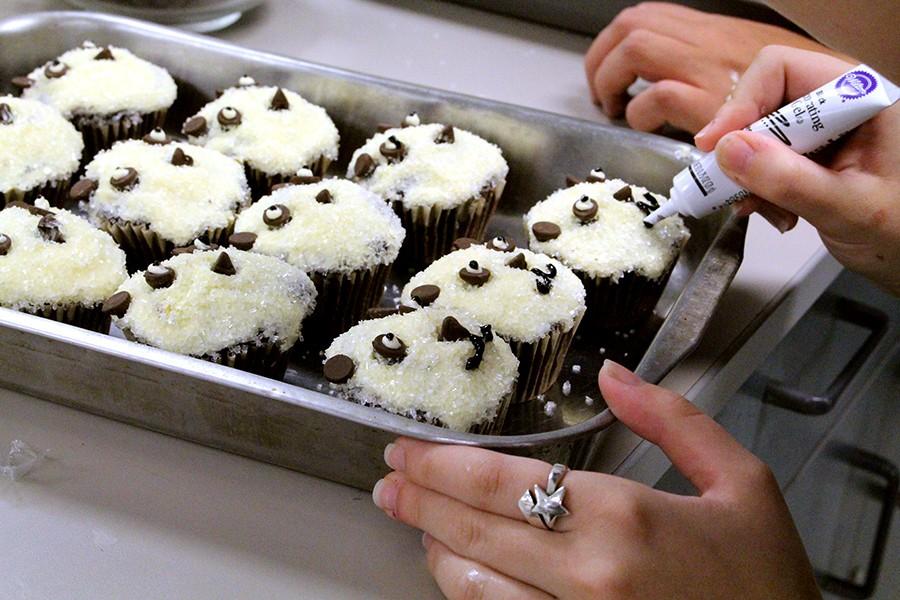 Bonnie Holt finishes off her panda cupcakes with a small mouth in black icing. 