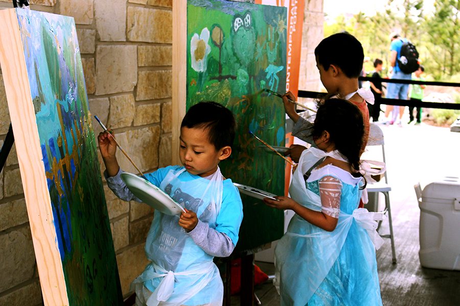 Children paint their rendition of their surroundings on wood provided by the Willow Fork District. 