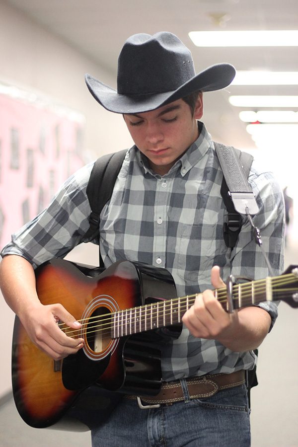 Sophomore Cameron Heinen strums his guitar. Students were encouraged to dress as characters on Monday.