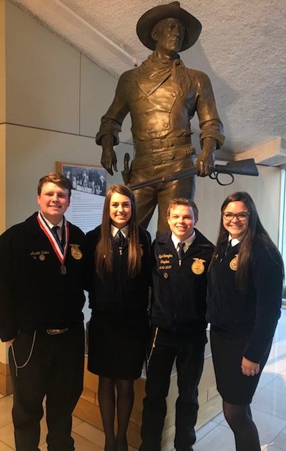 Austin Bates, Rachael Wheeler, Kyle Senogles and Calegh Milligan pose with a statue of John Wayne at the National Cowboy and Western Heritage Museum in Oklahoma City.