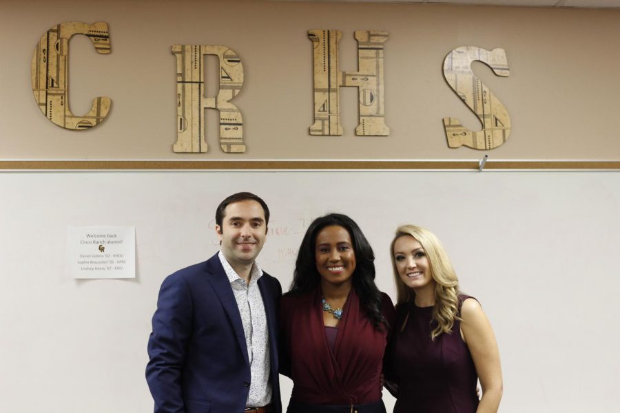 The alumni pose in front of a Cinco Ranch sign after a successful presentation.