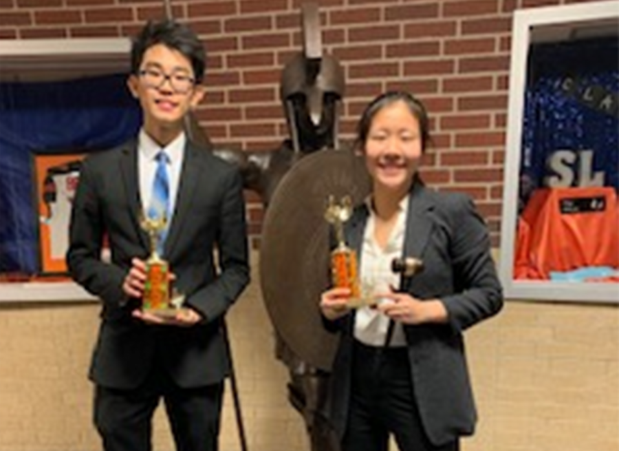 Sophomore Henry Ding and Anabelle Du pose with their public forum trophies.