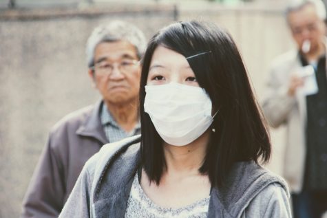 An Asian girl wears a mask in public. 673 cases of discrimination against Asian Americans were reported in March.