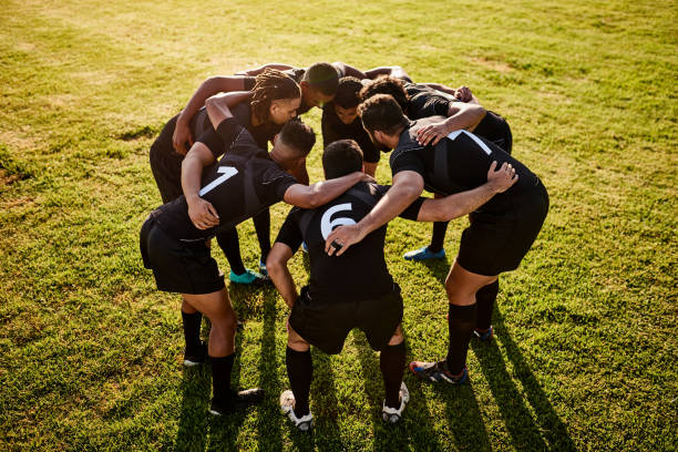 Full length shot of a diverse group of sportsmen huddled together before playing rugby during the day